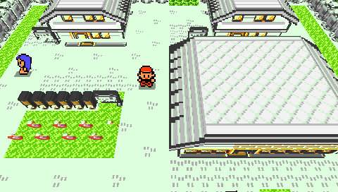 Pallet Town as a voxel diorama on a real PSP — carved trees, gabled roofs, an NPC and the player between the houses.